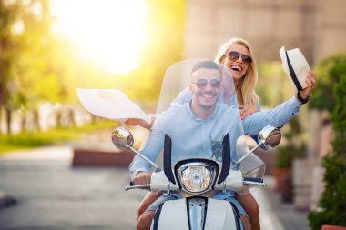 Birbirlerine aşık olan çift scooter'a biniyor, gezide eğleniyorlar. İnsanlar, aşk, seyahat ve tatil konsepti.