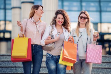 Şehir satış, alışveriş, turizm ve mutlu insanlar konseptinde alışveriş poşetleri ile mutlu kızlar.