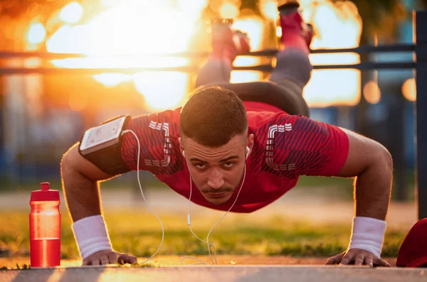 Sport motivation.Picture of a young athletic man doing push ups outdoors