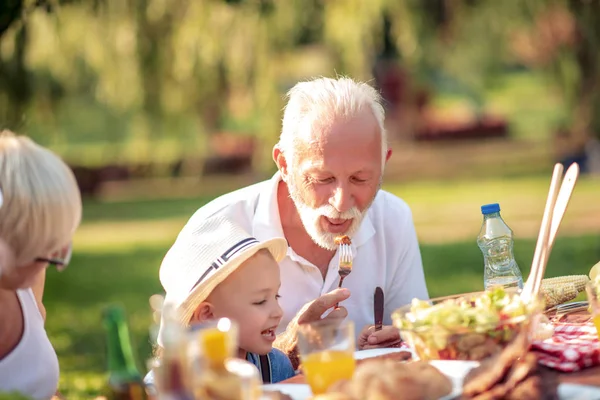 stock image Family having lunch in nature.Grandparents enjoying with their grandson.