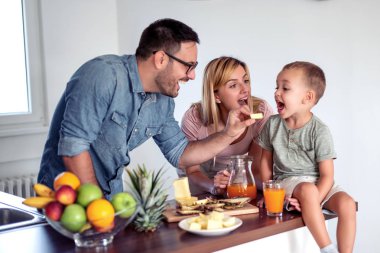 Mutlu bir ailenin portresi yemek hazırlıyor ve mutfakta eğleniyor..