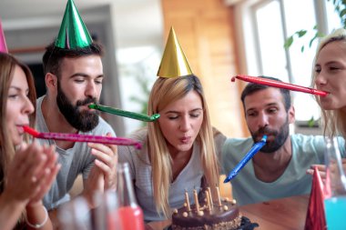 Bir grup mutlu arkadaş evde doğum günü kutluyor..