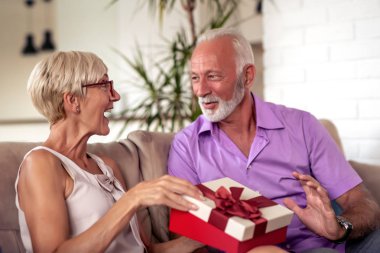 Karısına hediye veren kıdemli adam. Birlikte doğum günü kutluyor.