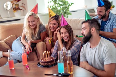 Bir grup mutlu arkadaş evde doğum günü kutluyor..