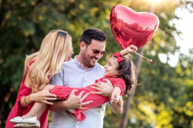 Mutlu genç aile parkta bir yaz gününde birlikte vakit geçirmek.