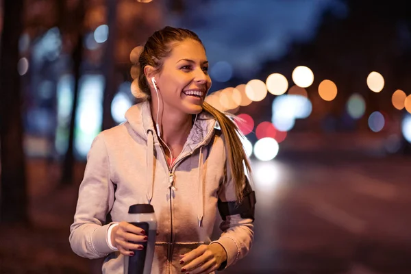 Fitness woman jogging in city at night. Sport and lifestyle concept