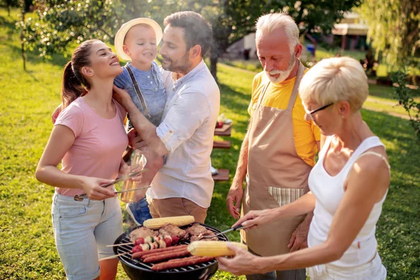 ピクニックでグリルの周りに集まった幸せな大きな家族 レジャー 食べ物 休日のコンセプト — ストック写真