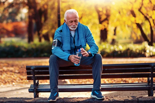 Senior Atleet Met Fles Water Ontspannen Het Rennen Bank Park — Stockfoto