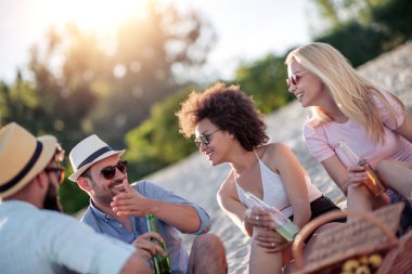 Bir grup arkadaş birlikte piknik yapar. Sahilde eğleniyorlar..