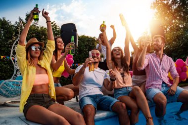 Arkadaşlarla havuz partisinin tadını çıkarıyorum. Bir grup arkadaş havuz başında parti veriyorlar..