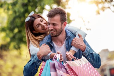 Güzel, genç bir çift alışveriş torbaları taşıyor ve birlikte eğleniyorlar. 