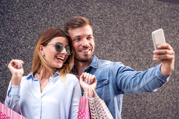Casal Feliz Com Sacos Compras Tirando Selfie Com Smartphone — Fotografia de Stock