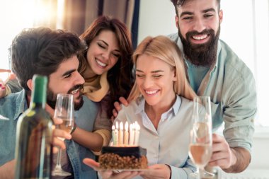 Doğum günü partisi. Mumlu bir pasta ile Arkadaşlar