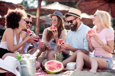 Arkadaşlar sahilde harika vakit geçiriyorlar, karpuz yiyorlar..