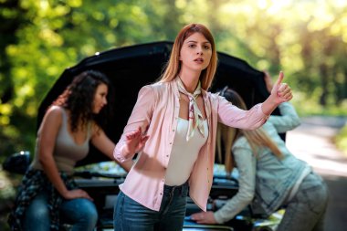 Yolda arabalarını tamir etmeye çalışan kızlar. Yardıma ihtiyacım var.