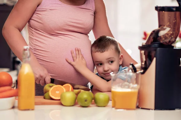 Mutter und ihr Kind machen frischen Orangensaft — Stockfoto