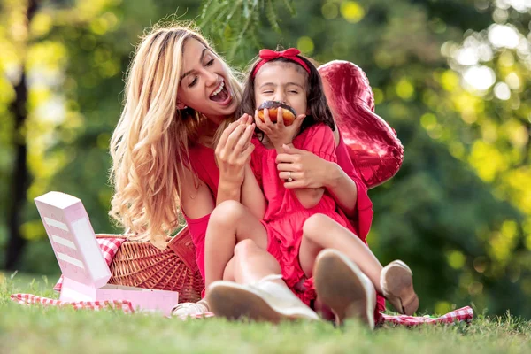 Молода Мама Дочка Розважаються Їдять Пончик Сидячи Ковдрі Парку — стокове фото
