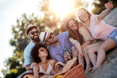 Yaz, tatiller, tatil ve mutluluk konsepti. Bir grup arkadaş telefonla selfie çekiyor..