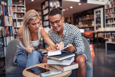 Eğitim konsepti. Üniversite öğrencileri okul kütüphanesinde sınava hazırlanıyor..