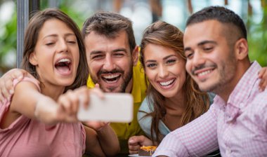 İnsanlar, eğlence, mutluluk ve iletişim konsepti. Arkadaşlar kafede buluşup pasta yiyor..