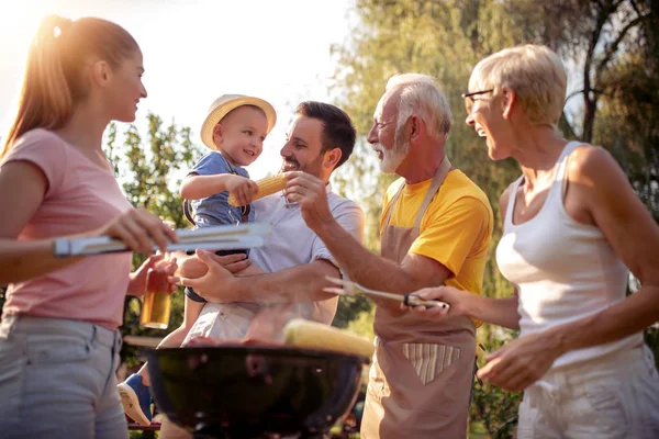 ピクニックでグリルの周りに集まった幸せな大きな家族 レジャー 食べ物 休日のコンセプト — ストック写真