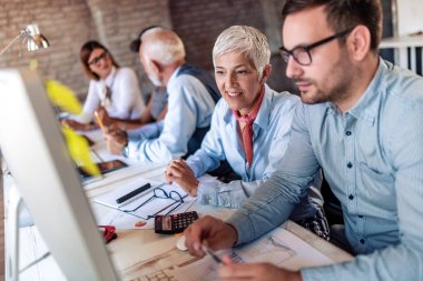 İş adamları proje sunumunu izliyor ve tartışıyor.