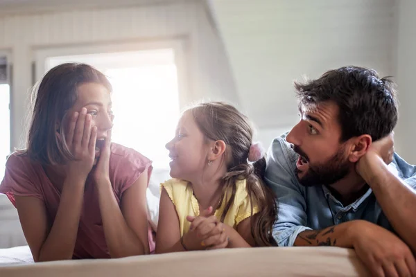 Happy family having fun in the bedroom,watching tv.