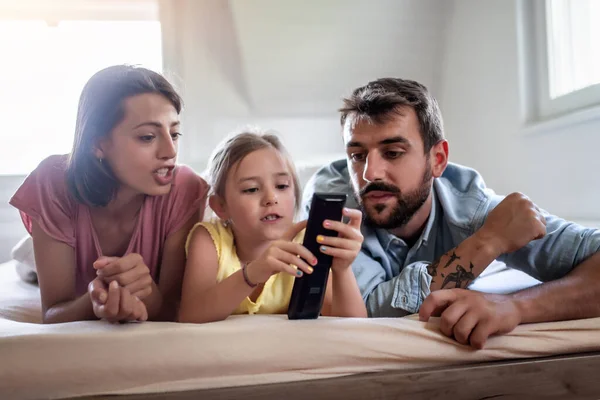 Leende Ung Familj Tittar Tillsammans Tillbringar Ledig Tid Hemma — Stockfoto