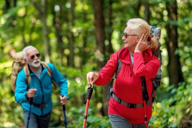 Senior couple of hikers walking in the forest.
