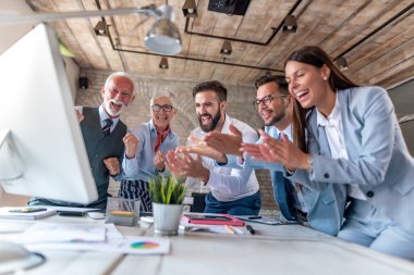 Bir grup iş adamı ofiste birlikte çalışır, başarıyı kutlarlar. İş, iş ve yaşam tarzı kavramı.