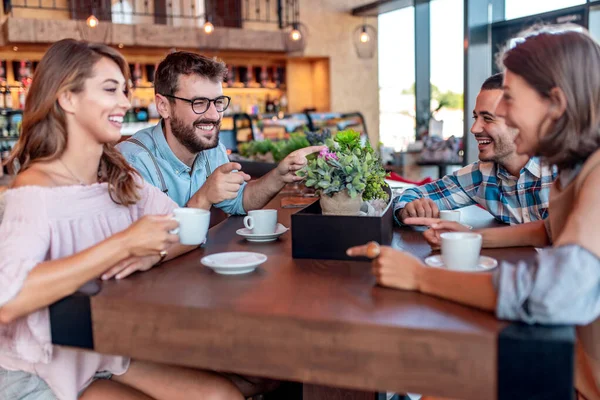 レストランで楽しい時間を過ごしている若い友人 コーヒーショップに座ってコーヒーを飲みながら笑顔の若者のグループ — ストック写真