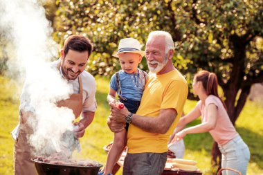 Barbekü zamanı. Mutlu büyük aile bahçelerinde barbekü yapıyor..