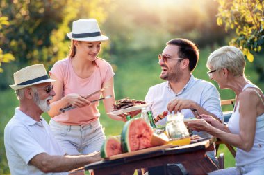 Mutlu büyük aile yaz bahçe partisinde öğle yemeği yiyor. İnsanlar, yemek, aşk ve mutluluk kavramı.