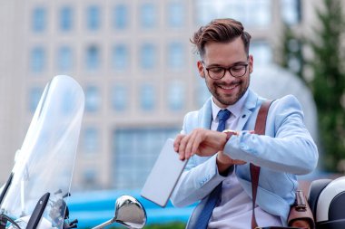 Çekici genç işadamı tablete bakıyor ve işten sonra gülümsüyor. İş, insan ve yaşam tarzı kavramı.