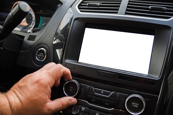 The male driver controls the settings of the car car audio system. Touch screen is white blanked