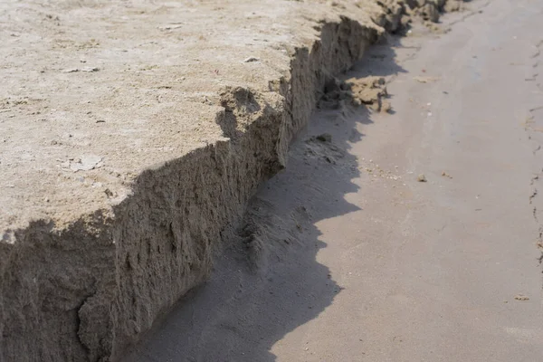 Sandy river shore, washed away by water during the flood. Selective focus