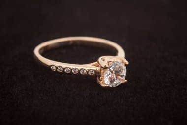 Koyu arka plan üzerinde altın pırlanta yüzük. Nişan yüzüğü 