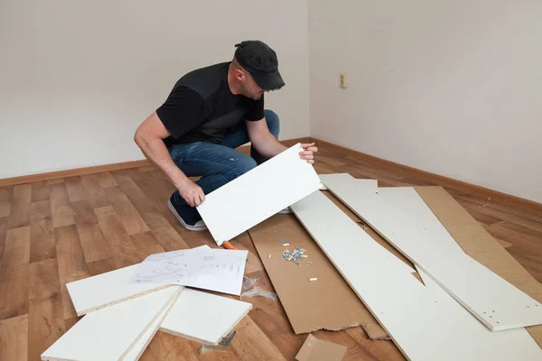 男は新しい家でカジュアルな組み立て家具を身に着けていた 自宅で大工の修理や組み立て家具 — ストック写真