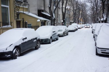 Kar fırtınasından sonra şehir caddesi. Karla kaplı arabalar.
