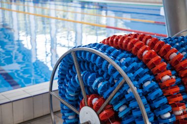 Havuzun yanındaki bobin deposunda yüzme şeritleri işaretleri var. Atletizm ve yüzme için havuz şeridi çizgileri.