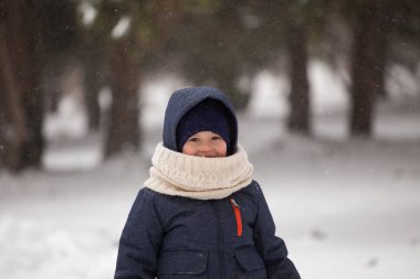 Parktaki küçük mutlu çocuk kışın kar altında