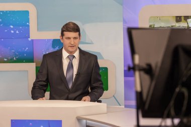 Televizyon stüdyosunda erkek sunucu. Canlı yayın.