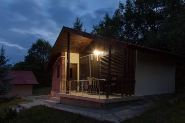 Ormanın içinde ahşap bungalov geceleri. Tatil apartmens