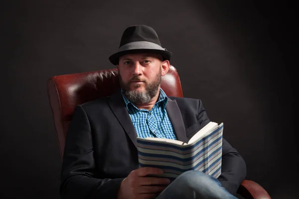 Portrait Man Beard Hat Sitting Leather Chair Reading Book — Stock Photo, Image