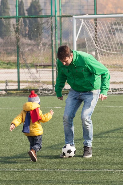 サッカー フットボール 公園で日曜日に息子と若い父親 — ストック写真