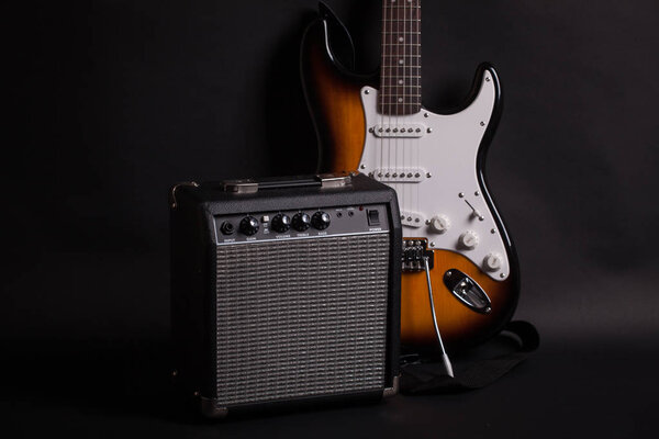 Amplifier and electric guitar on dark background