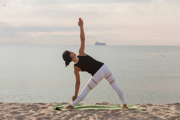 Женщина Практикует Йогу Пляже Поза Треугольника Триконасана Спорт Открытом Воздухе — стоковое фото