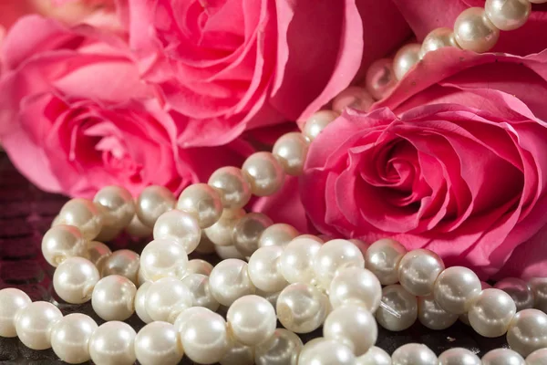 Красивые розовые розы и белый жемчуг. Концепция красоты для женщин. — стоковое фото