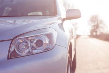 Yeni gümüş renkli SUV 'nin önünü kapatın. Modern bir arabanın ayrıntıları. Işık.