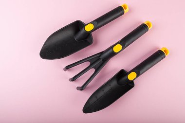 Pembe arka plan üzerinde yeni bahçe araçları 